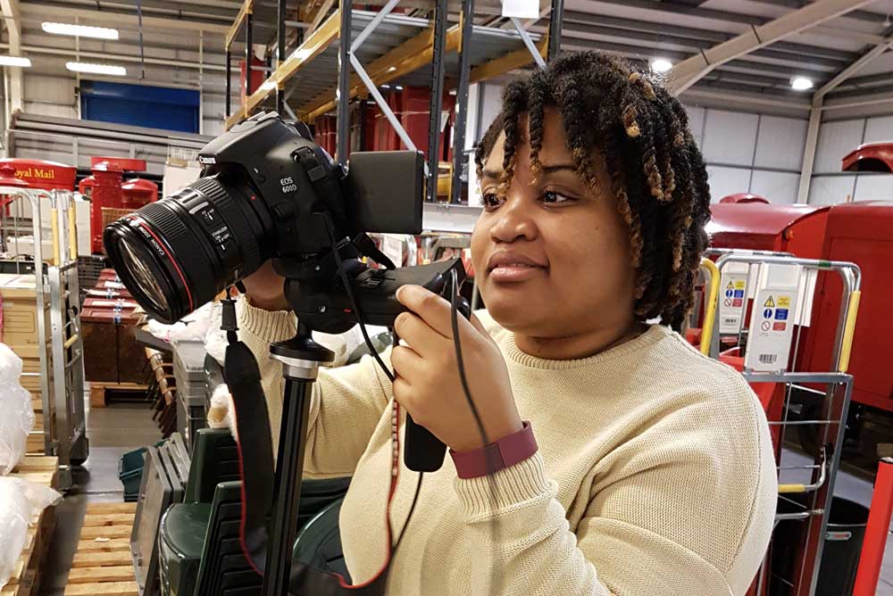 Placement student Whitney Christopher photographing objects at the Postal Museum Store