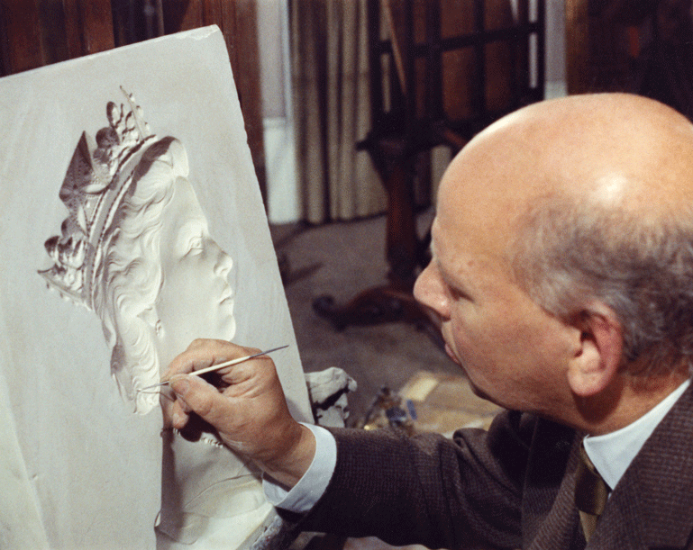 An image of Arnold Machin working on one of the plaster casts of Queen Elizabeth II.