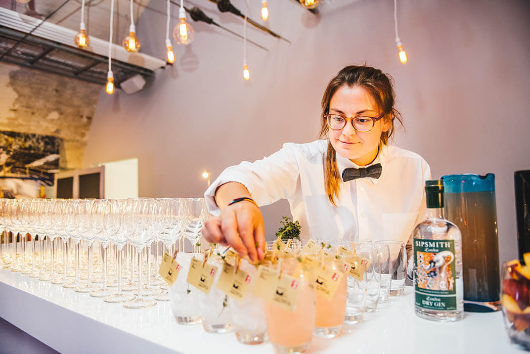 A member of catering staff arranging glasses