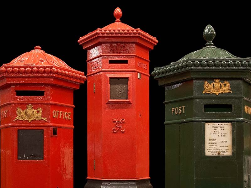 Two red pillar boxes and one green pillar box.