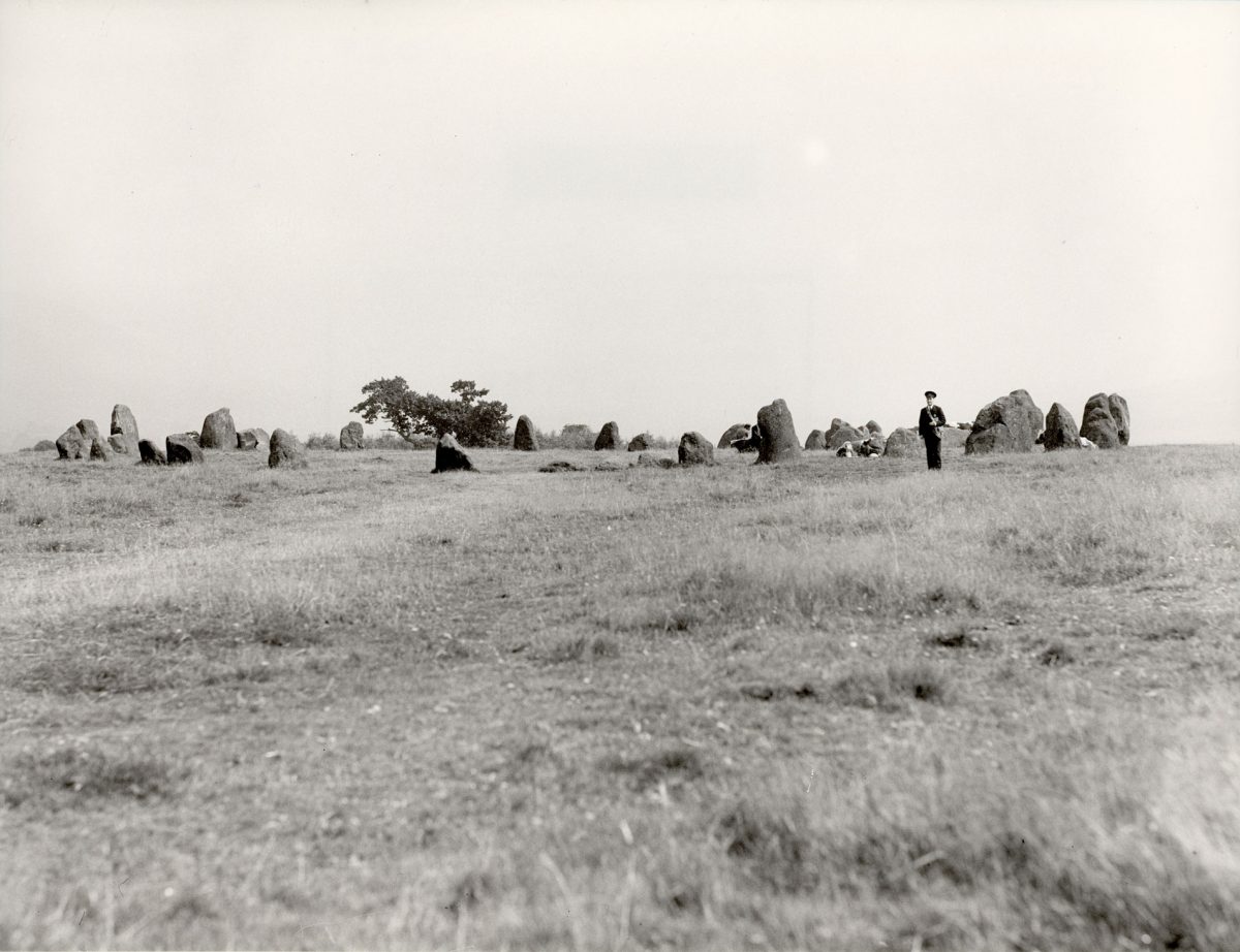 Black and white photograph of a postman at Castlerigg Stone Circle.