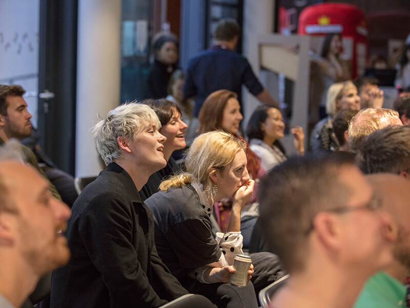 Photo of visitors to The Postal Museum listening to a talk.