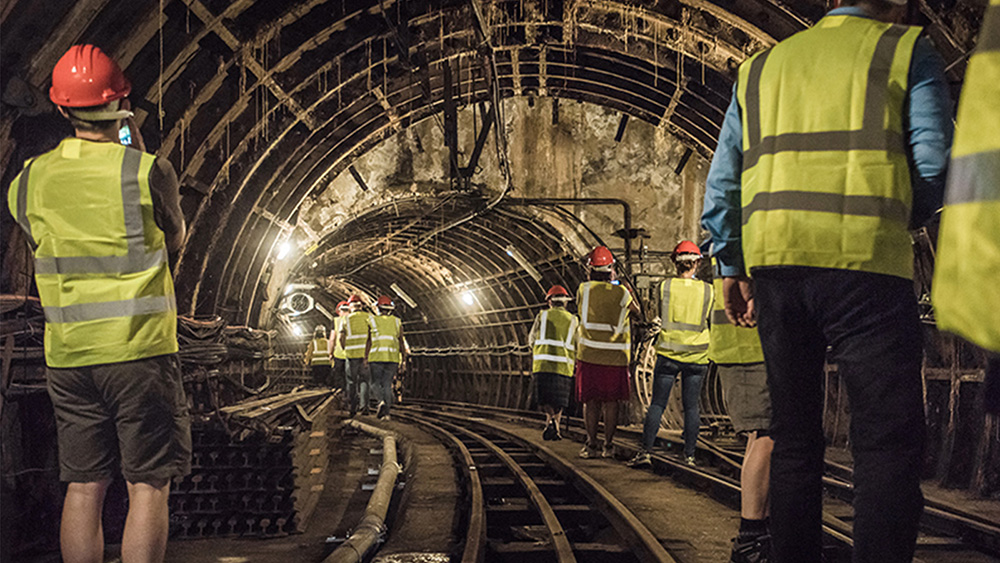 People in high visibility jackets and hard hats underground on the Tunnel Walks