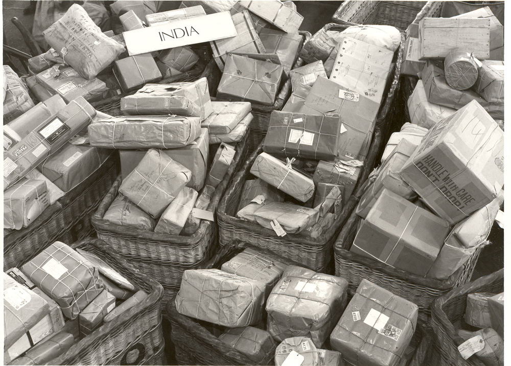 Black and white photograph of numerous parcels ready to be transported to India.