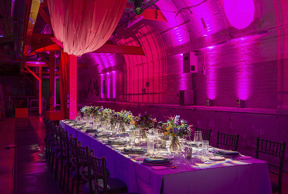 An event table set up in the Mail Rail venue space with purple lighting and decor.