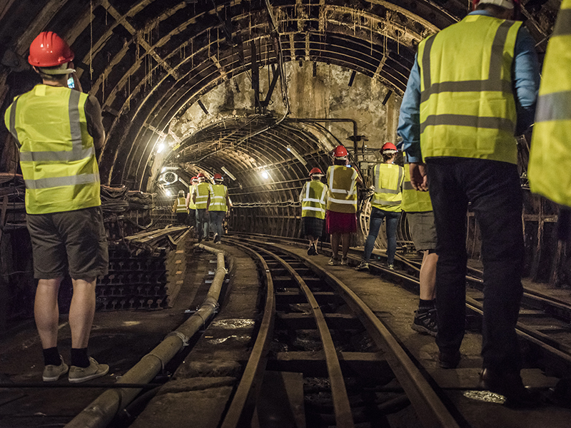 Photo of a group walk through the abandoned underground tunnels of London's old Post Office Railway.