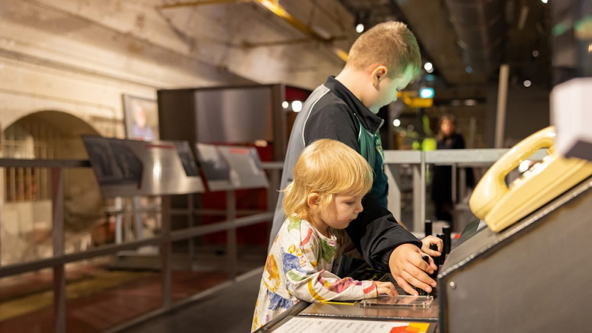 Two young children playing with an interactive exhibition.
