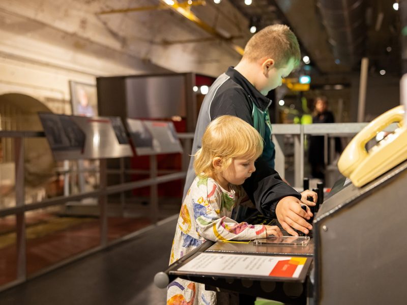 Two young children playing with an interactive exhibition.