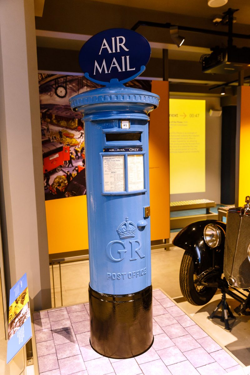 Photo of a blue airmail pillar box in the museum gallery space.