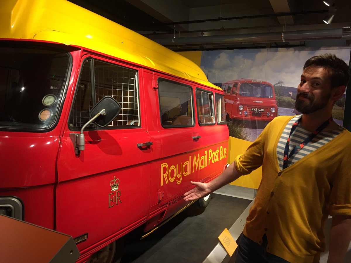 Tim Dunn stands by a post bus in The Postal Museum 