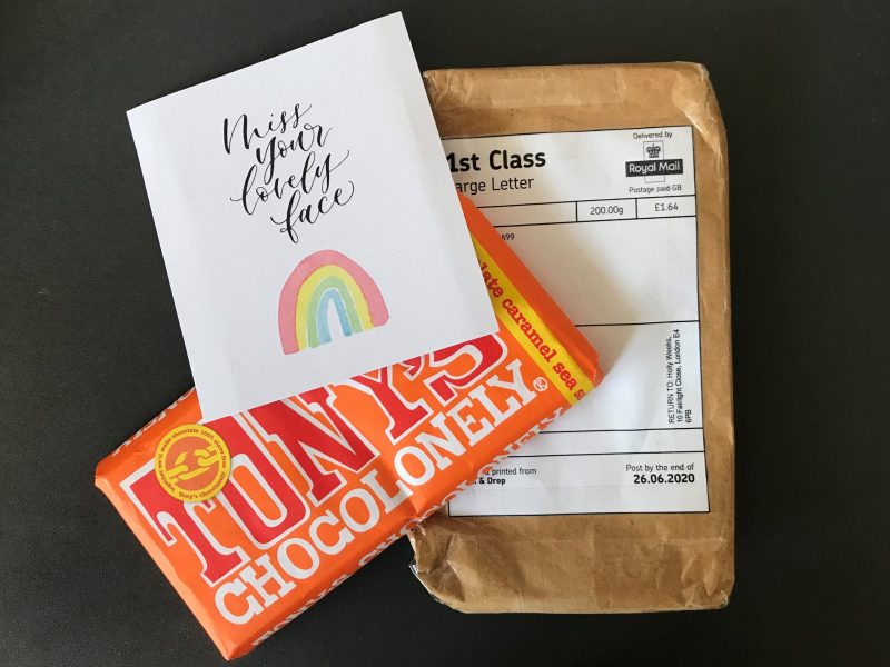 A parcel dated June 2020 with a chocolate bar and a card that reads 'Miss your lovely face'