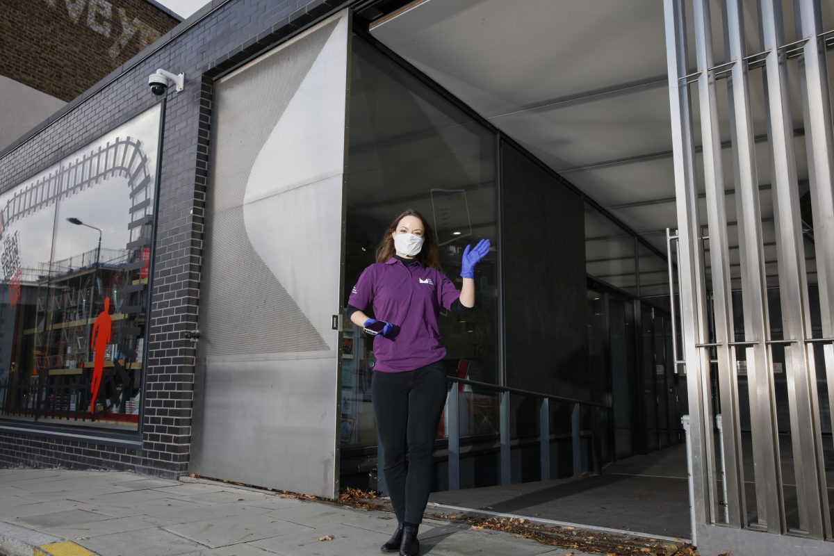 Visitor host stands outside The Postal Museum entrance