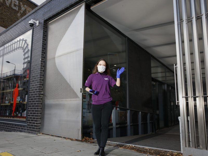 Visitor host stands outside The Postal Museum entrance