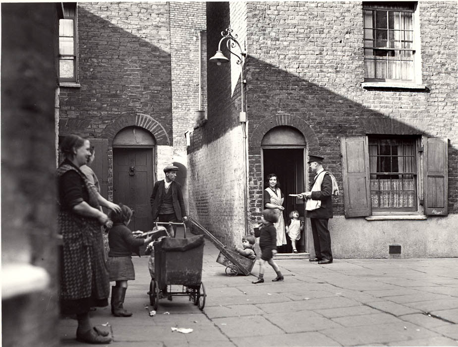 ‘Postman delivering mail in Wapping’. Black and white photograph. 1935. (POST 118/252)
