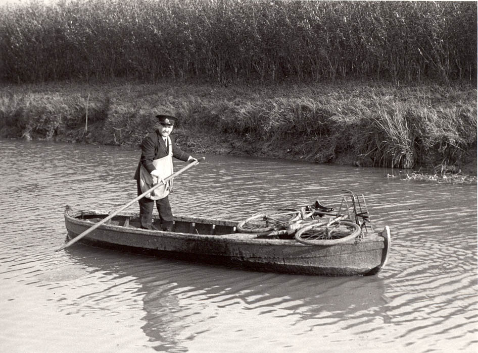 ‘Wisbech - postman delivering by boat’. Black and white photograph. 1937. (POST 118/591)
