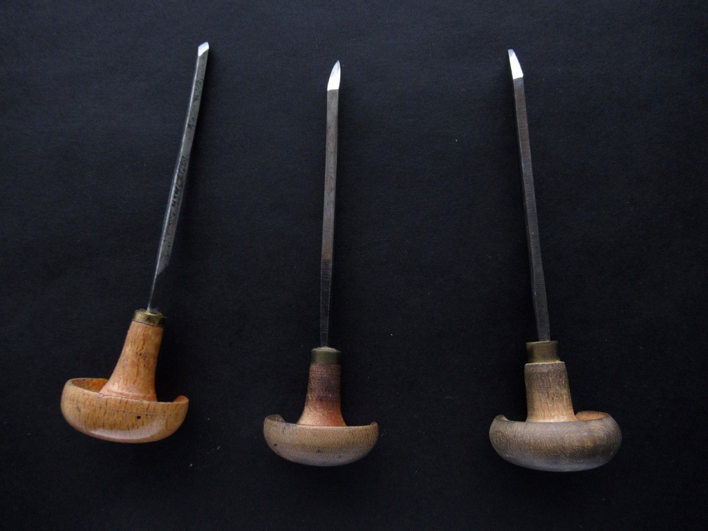 Photograph of three engraving tools with wooden handles. 