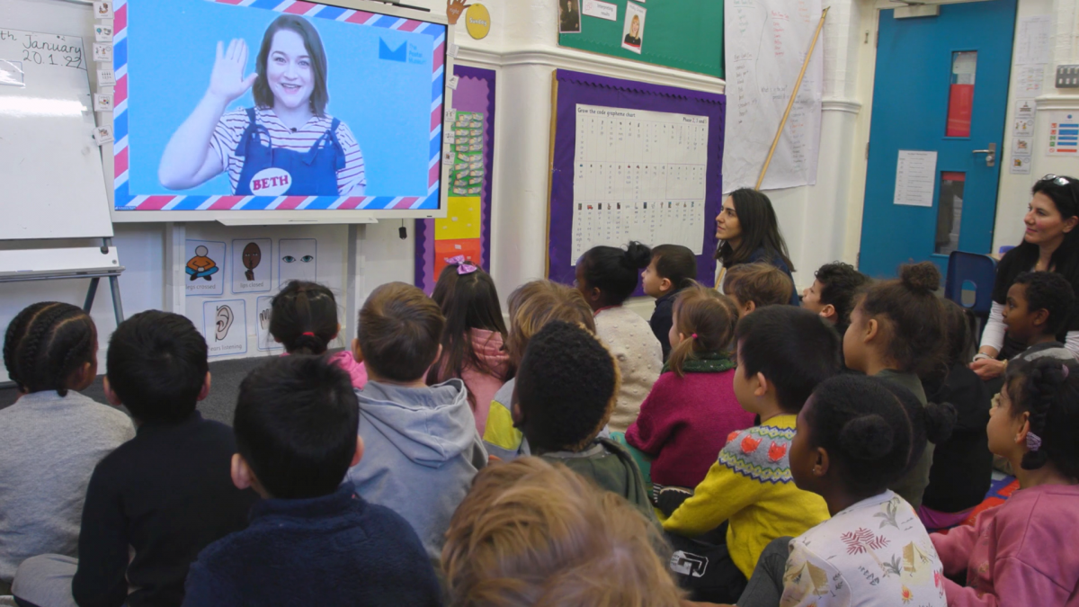 The Jolly Postman virtual session - photo showing children in a classroom watching the session on a screen.