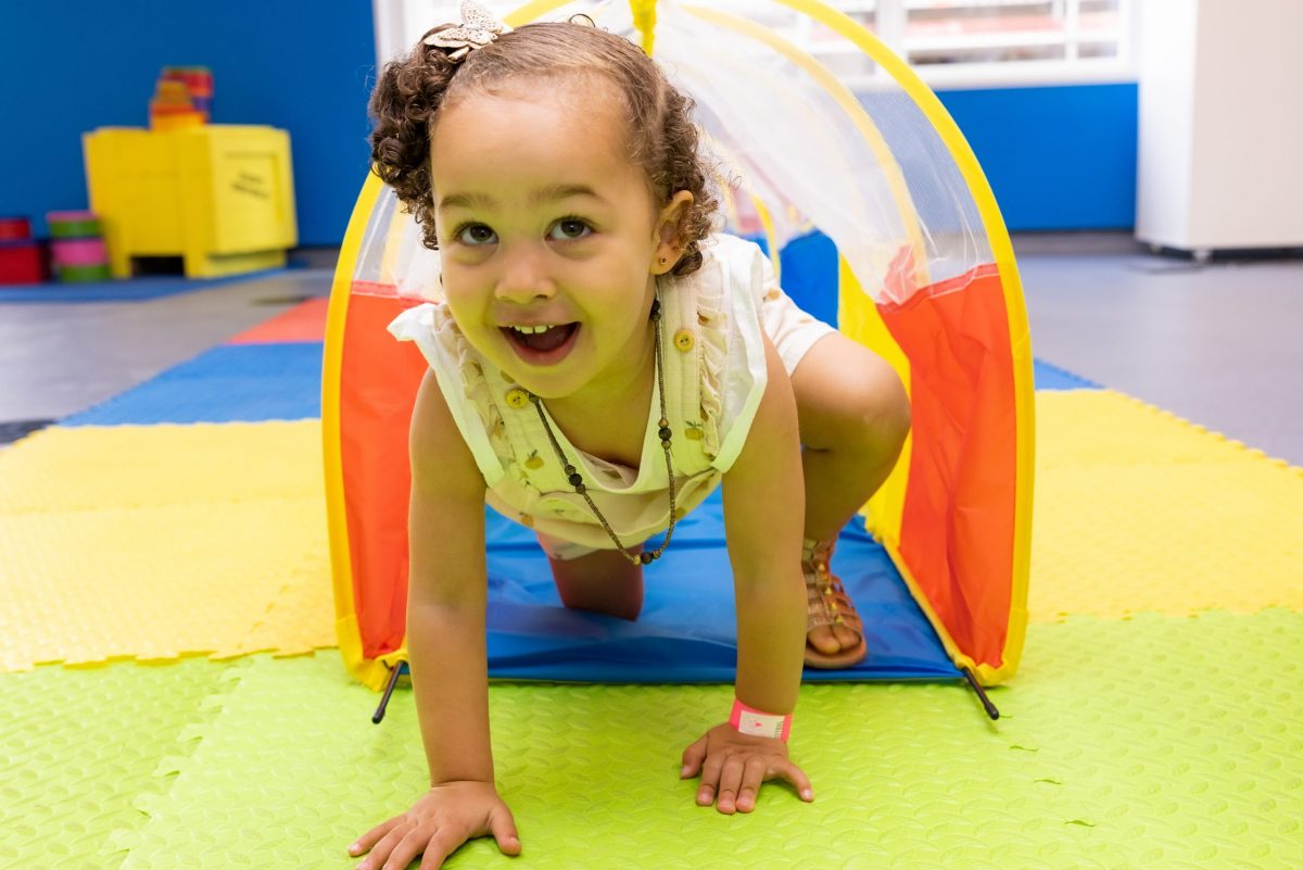 Small child crawling through a tunnel during a play session
