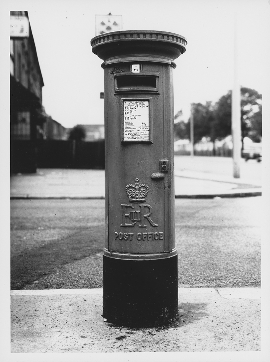 Photograph. Image orientation: portrait. Black and white. Pillar box with 'EIIR' cypher, Haringey, London.