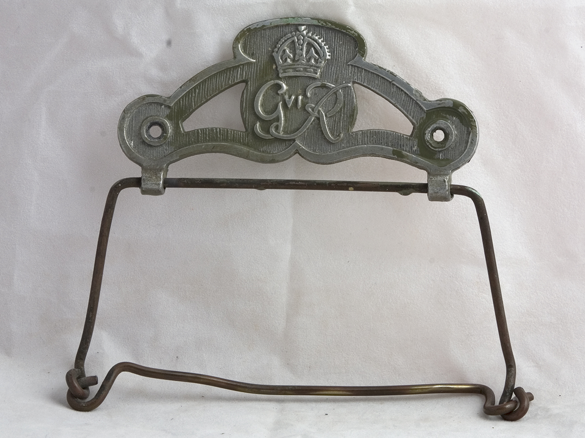 An old, grey metal Toilet Roll Holder with George VI cypher.