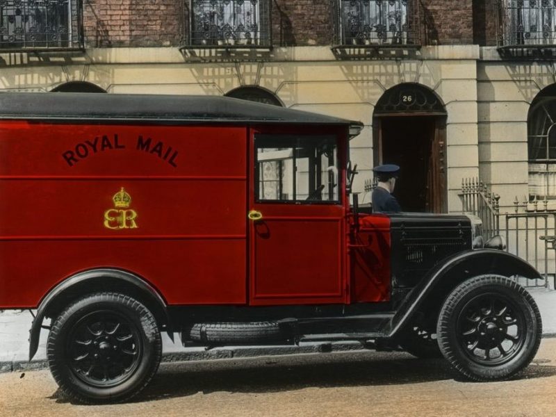 An old red post van marked with the letters 'ER' on the side in yellow.