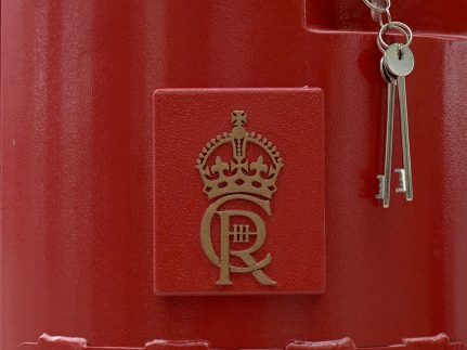 A closeup of the Charles III cypher on a postbox