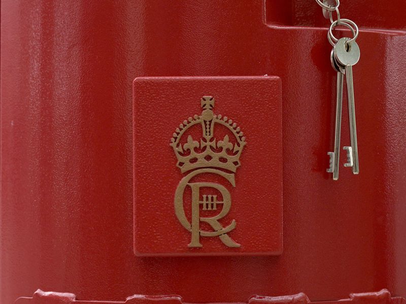 A closeup of the Charles III cypher on a postbox
