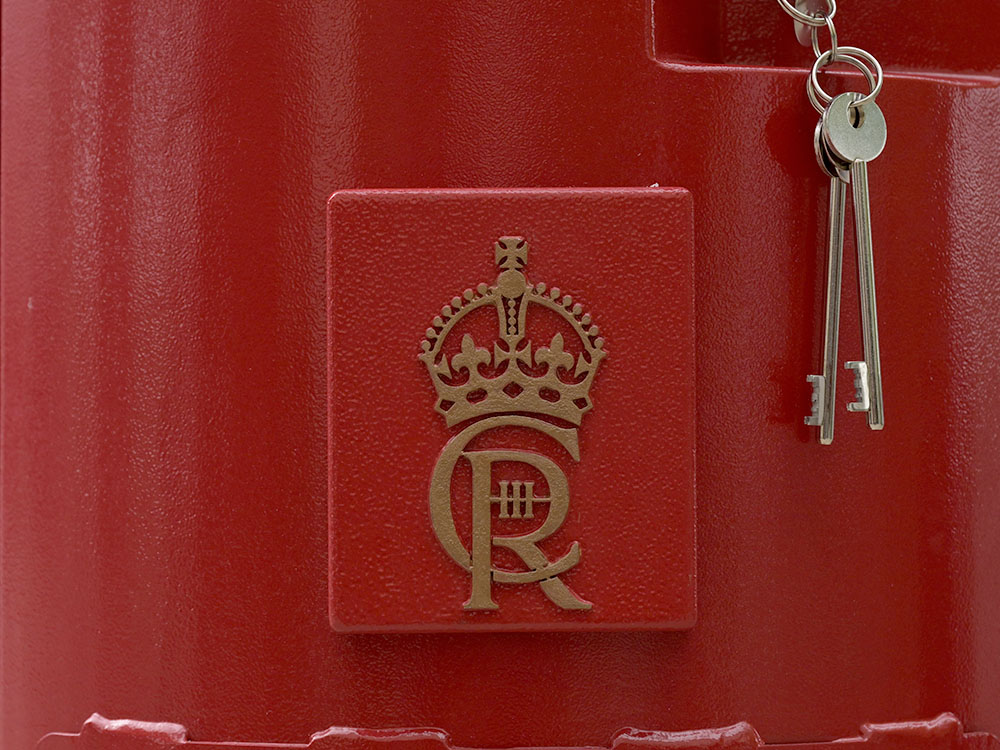 A closeup of the Charles III cypher on a postbox