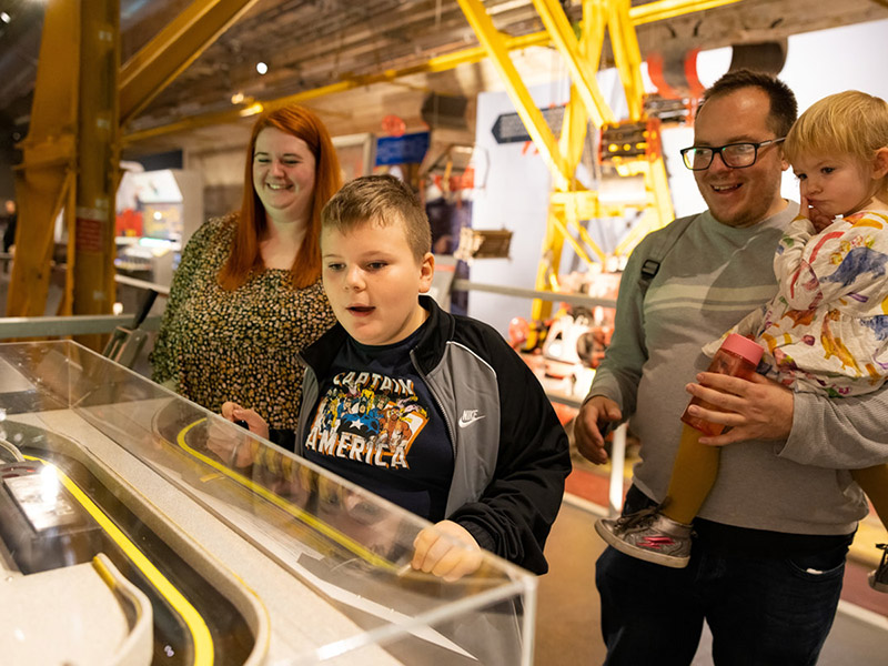 A photo showing a family playing with an interactive exhibit in The Postal Museum.