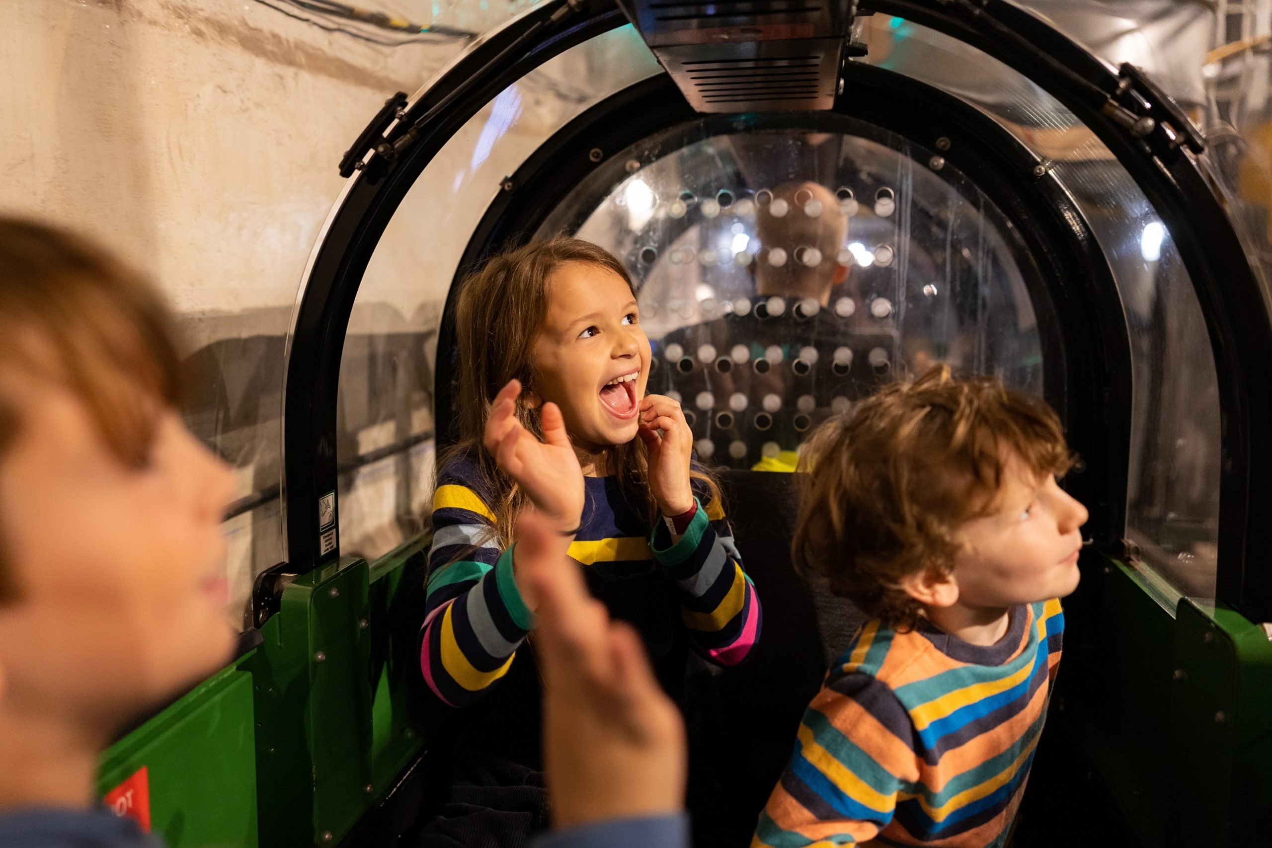 Happy children sat in a Mail Rail carriage.