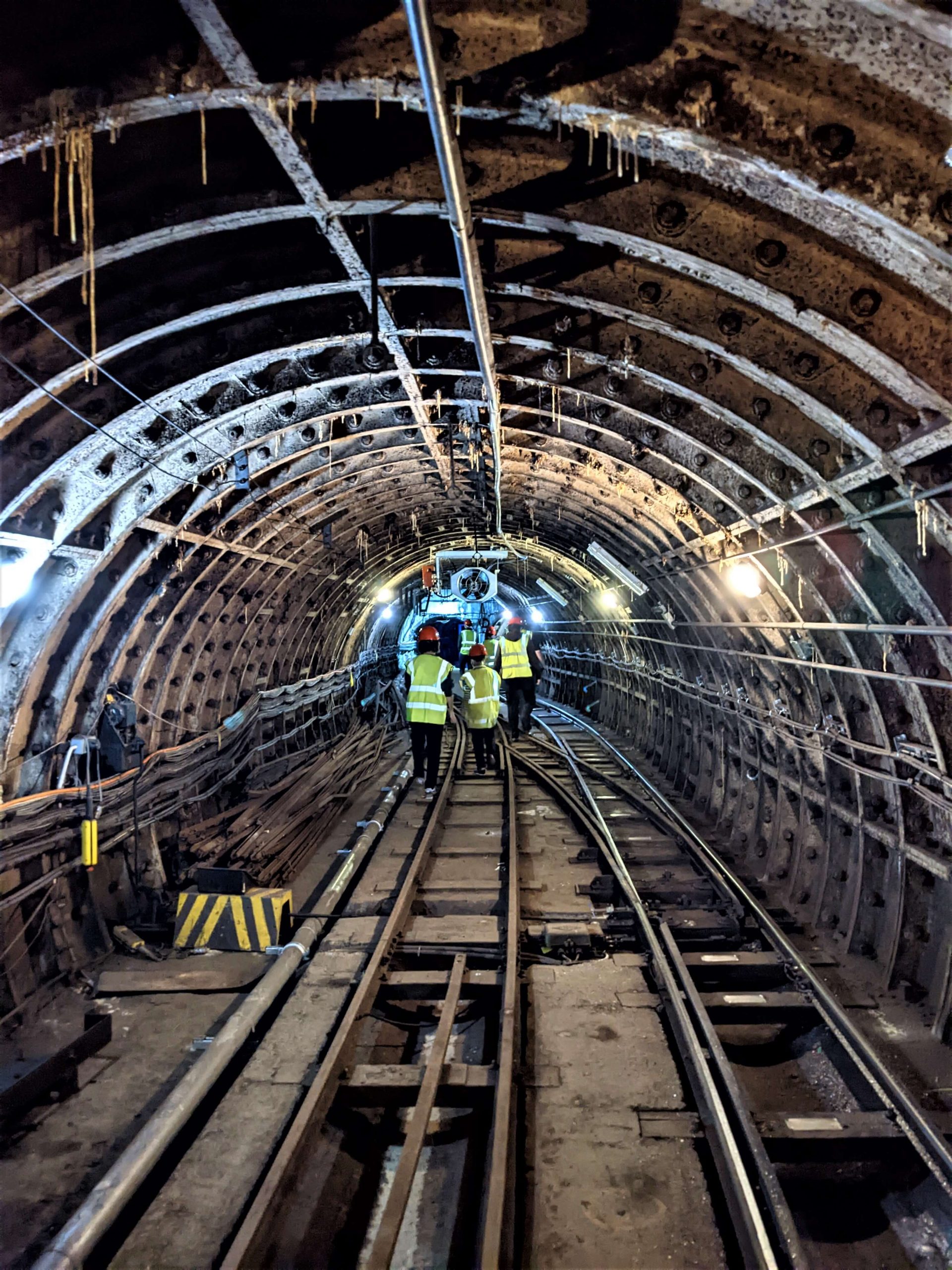 Group members in high-vis jackets walking along the train tracks