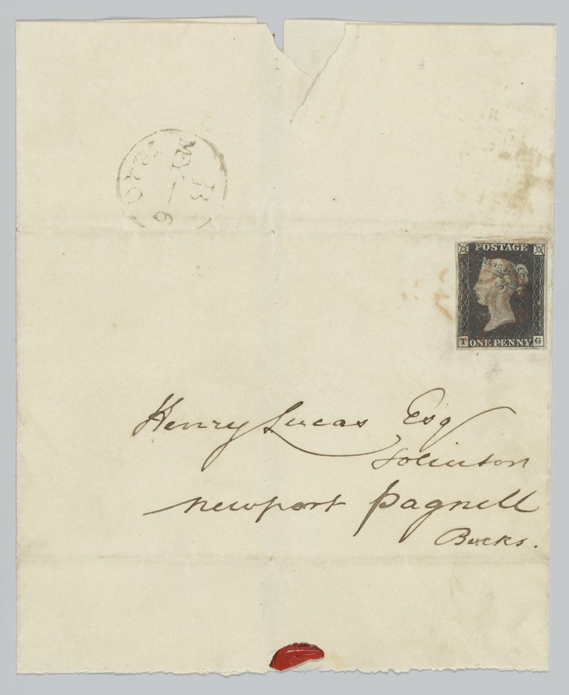 A very old envelope with the Penny Black stuck on to it. The stamp is black with a sepia portrait of a young Queen Victoria in the middle. (POST 141/04/03)