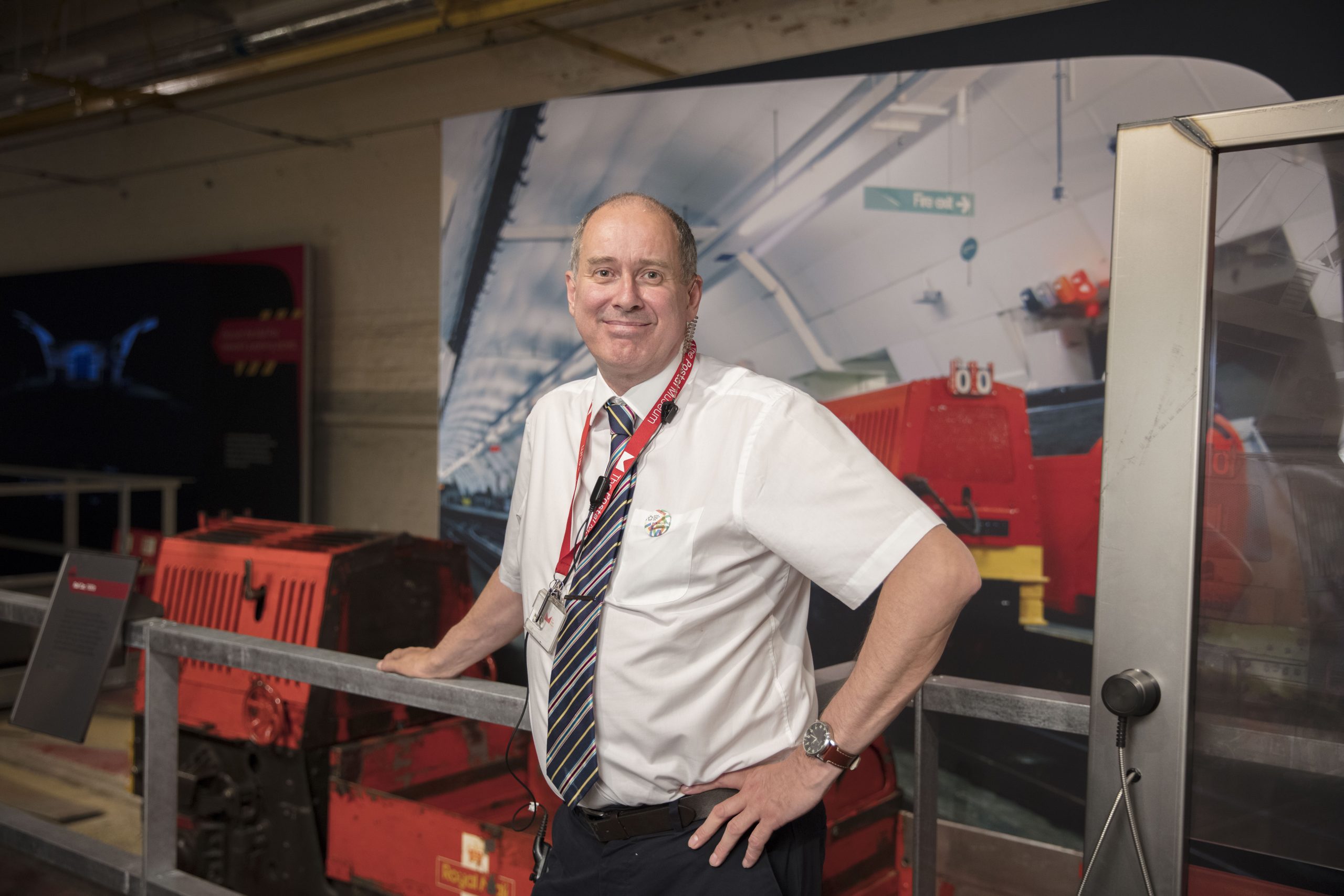 Staff member Warwick, wearing a white shirt, in front of Mail Rail