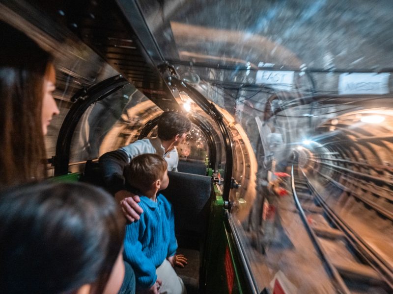 This slightly blurry image gives you a feel for the experience riding Mail Rail. The child and parent passengers look in awe at the dimly-lit Mail Rail tunnels.