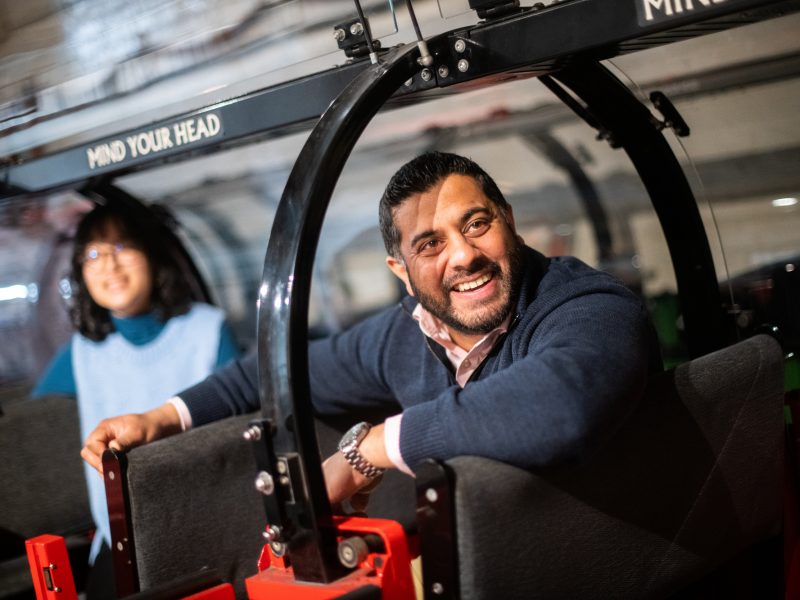 This man. attending The Postal Museum as part of the group, is dressed smart-casually and looks happy and relaxed.