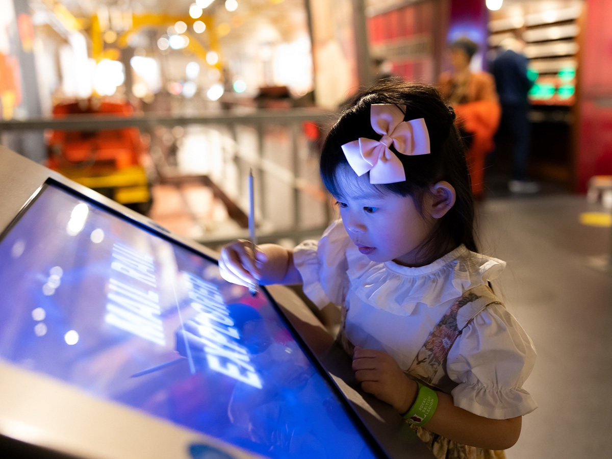 Photo of a toddler playing with an interactive game in the exhibitions.
