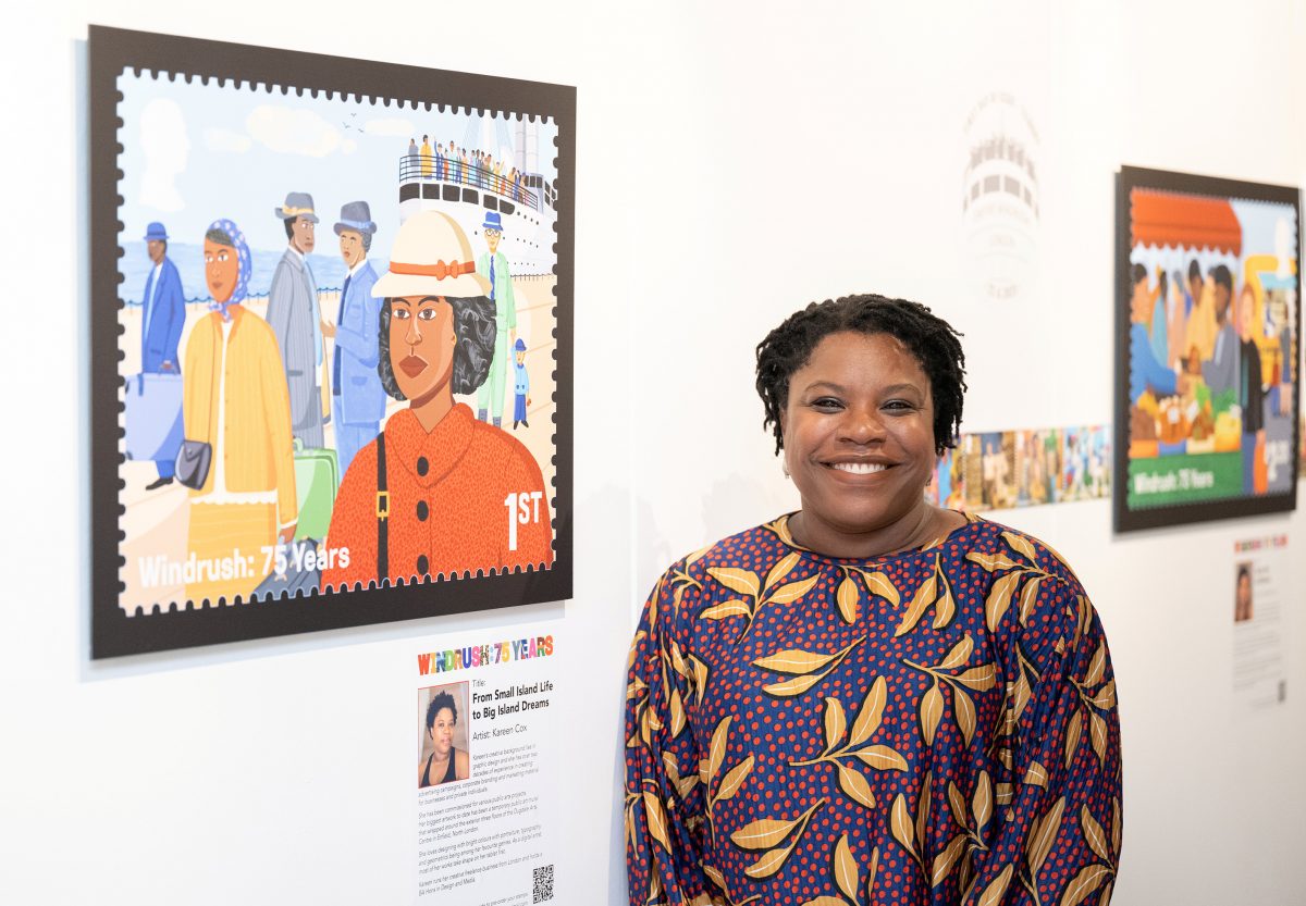 Kareen stands in front of one of her stamp designs with a smile on her face.
