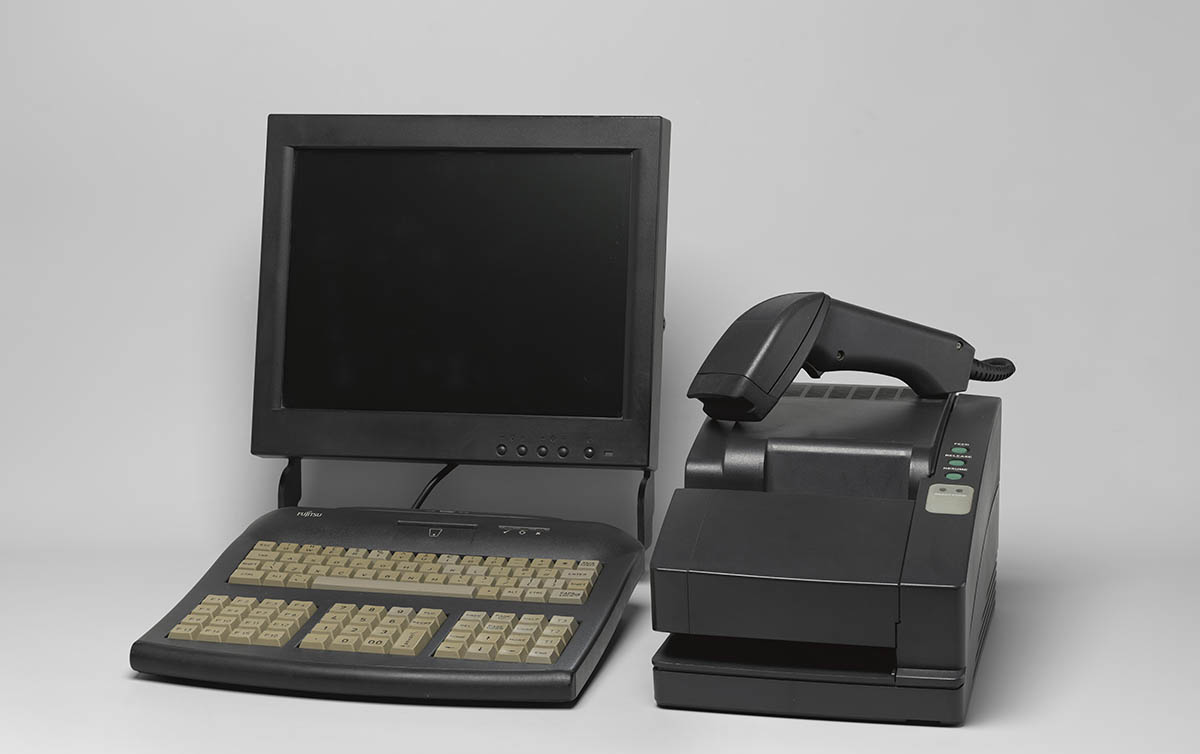 A Horizon computer terminal. A black computer monitor on a desk with a keypad and a scanning device.