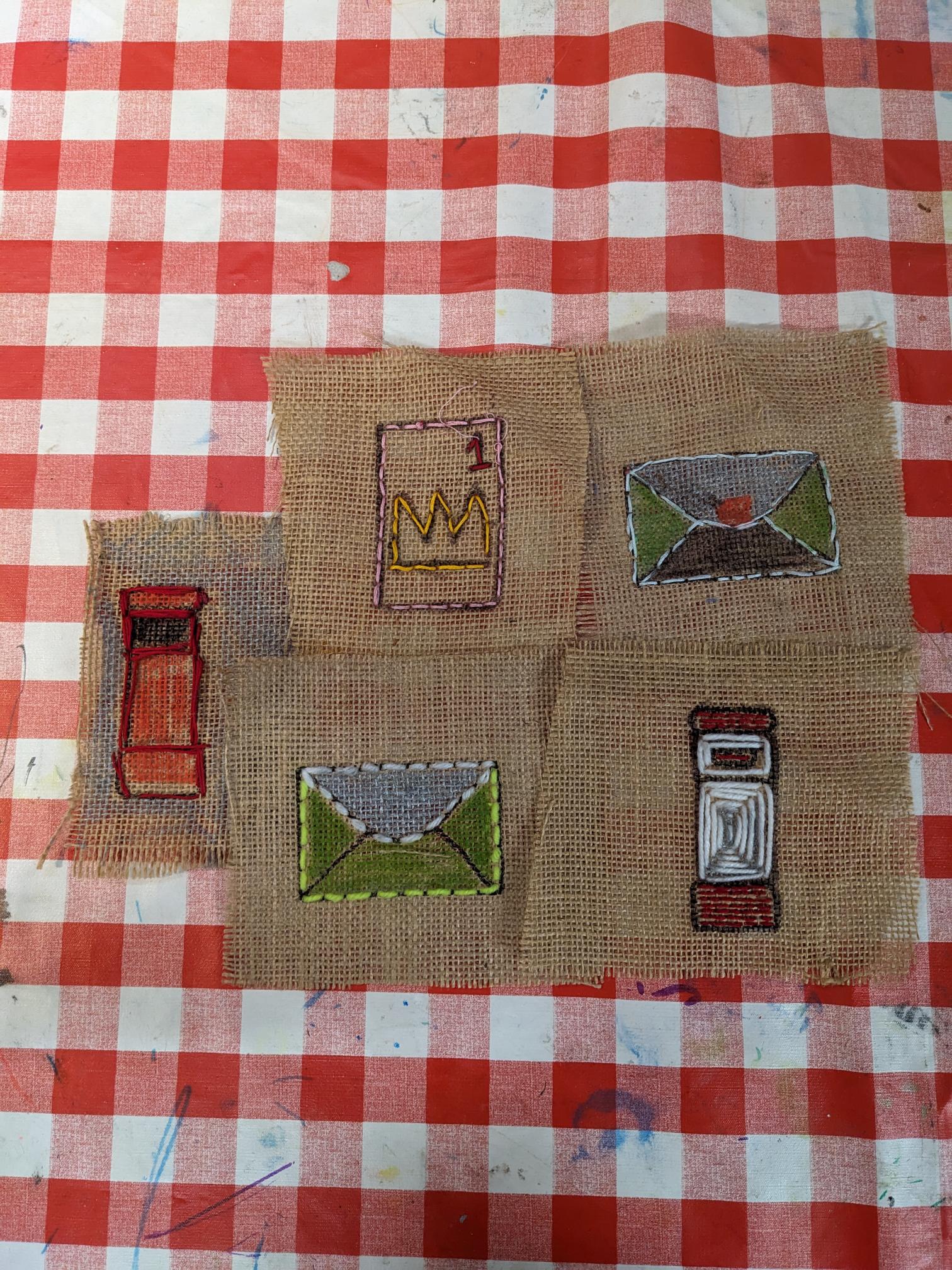 Raffia patches with different designs sew on them: a red post box, an envelop, a stamp