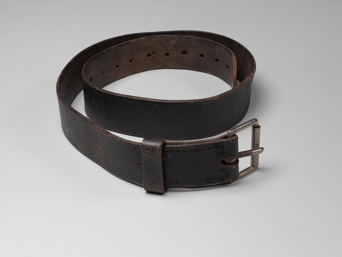Brown leather belt with silver buckle. The leather is worn from use.