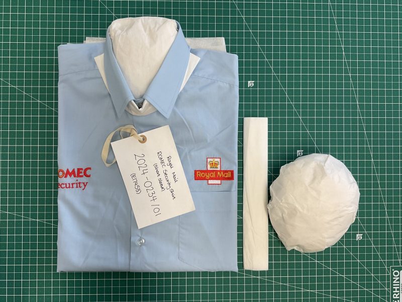 A Royal Mail shirt folded and filled with protective tissue.