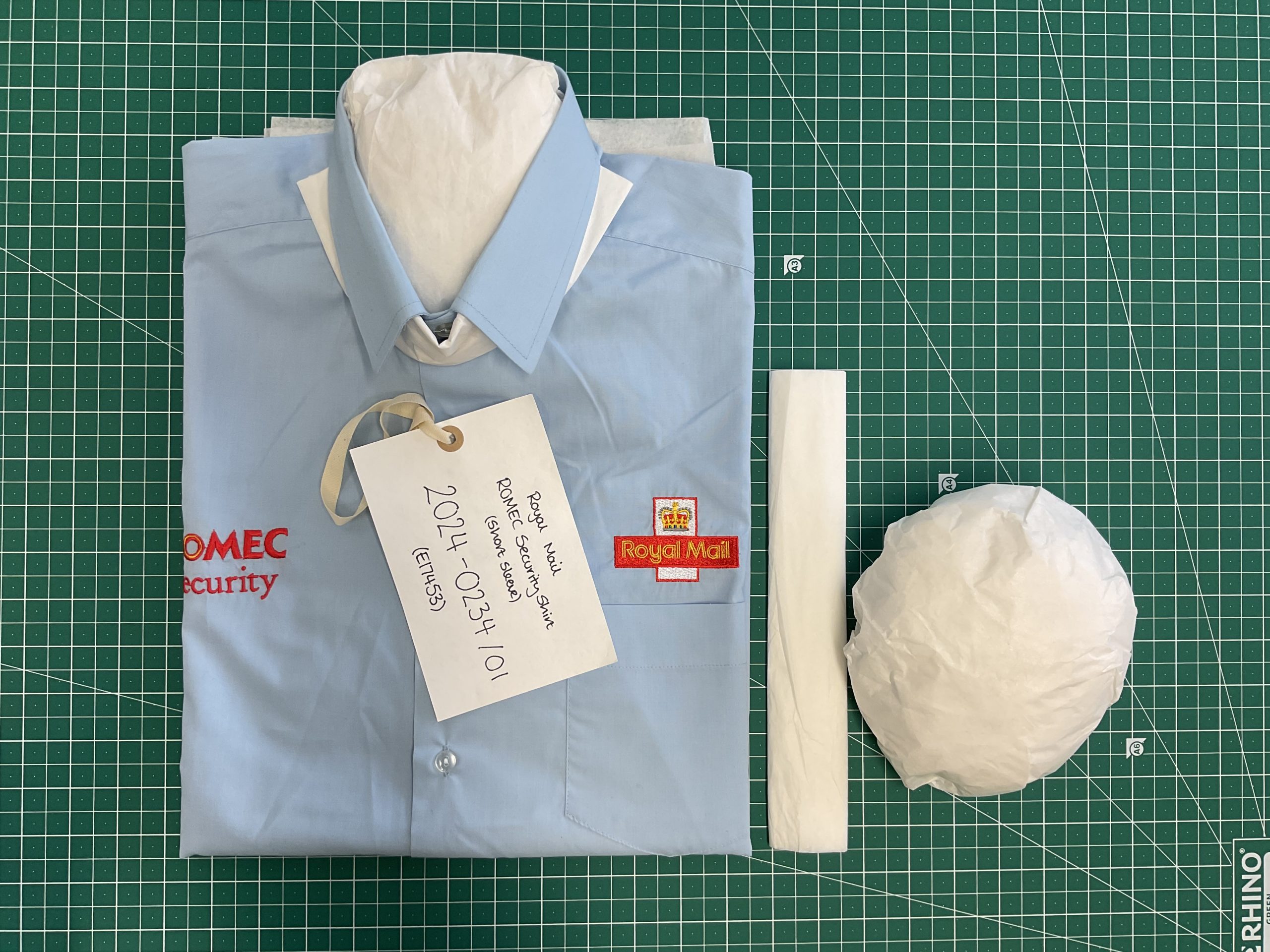 A Royal Mail shirt folded and filled with protective tissue.