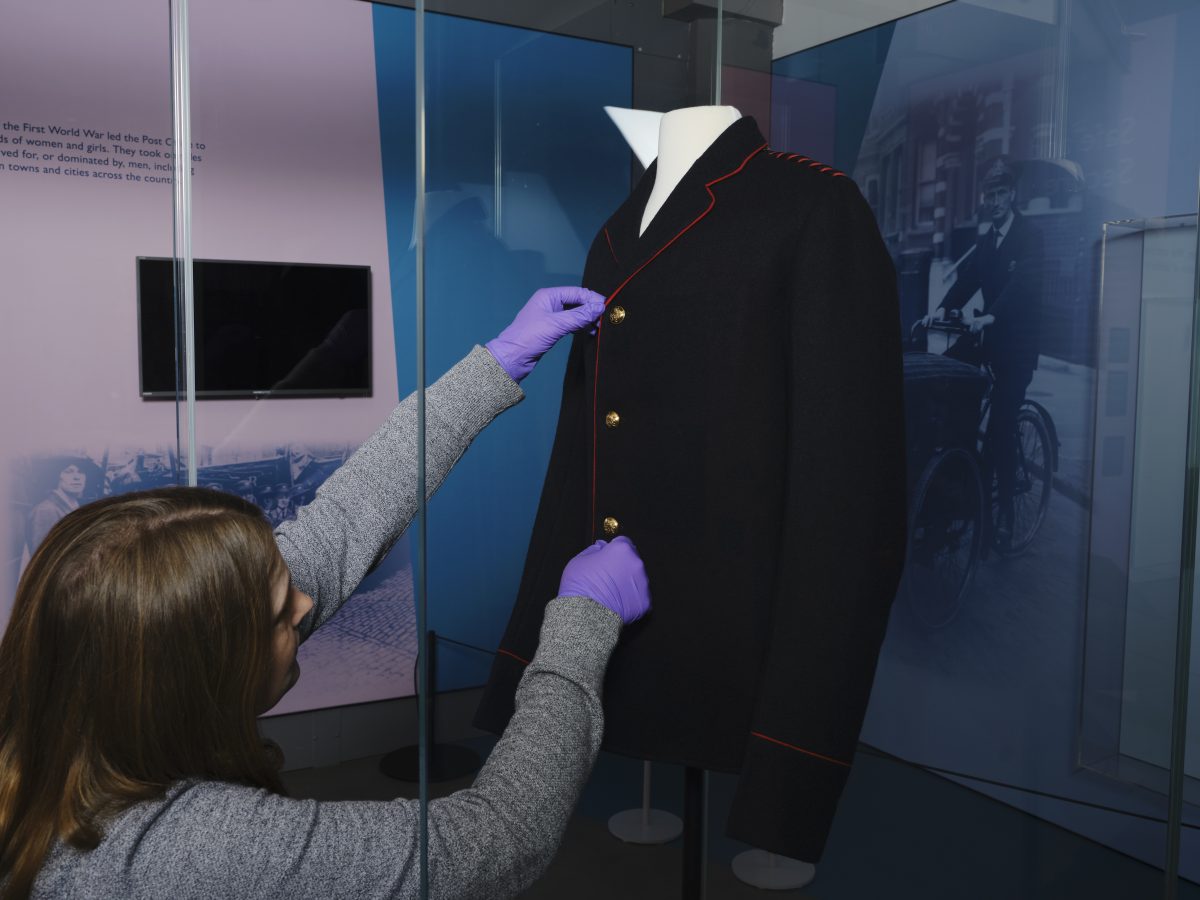 A person dressing a mannequin with a jacket