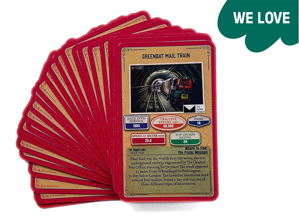 The red and gold cards are fanned out onto a table. The top card shows infomation about the Greenbat Mail Train