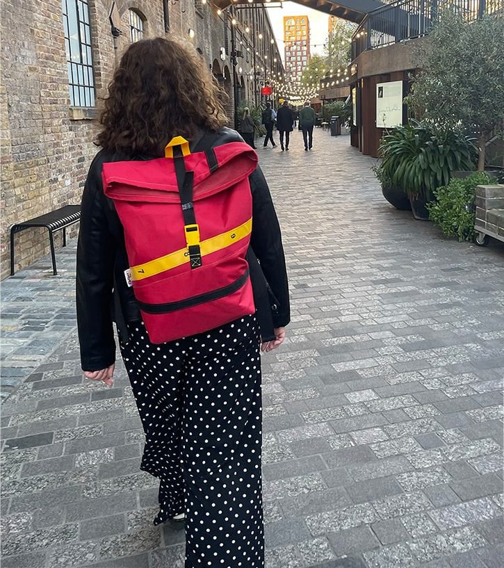 A woman is wearing the red rucksack on her back