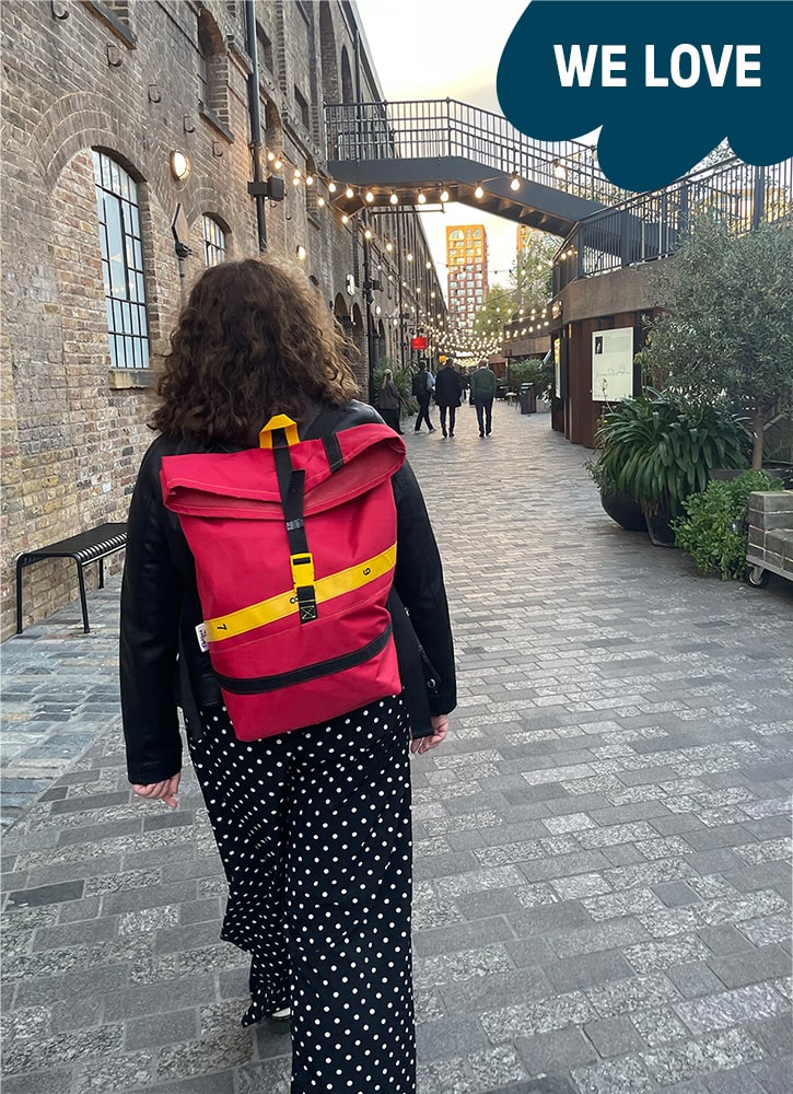 A woman is wearing the red rucksack on her back