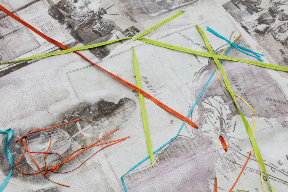 Artwork created at the workshop, with maps and old black and white photos woven together with coloured ribbons and thread.