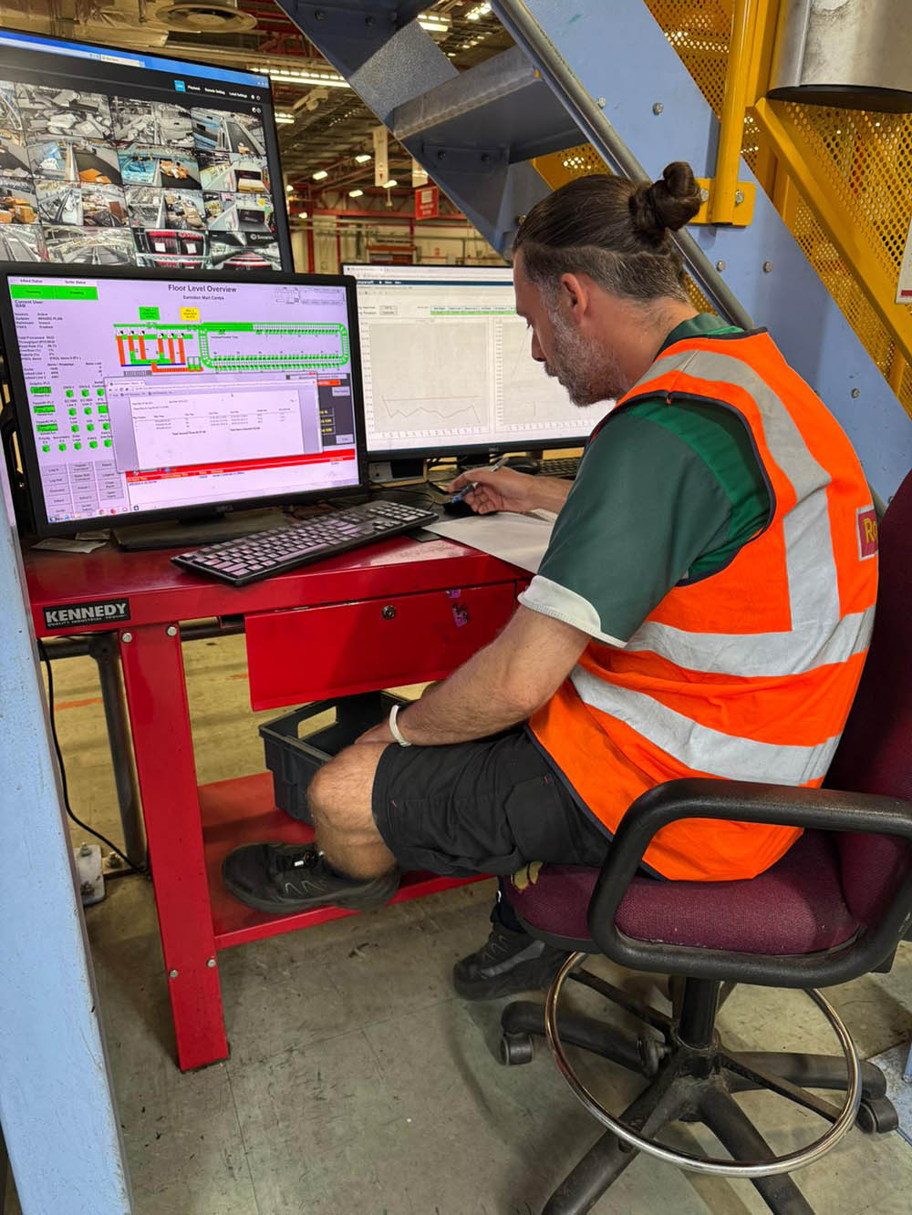 A postal worker at a computer desk.