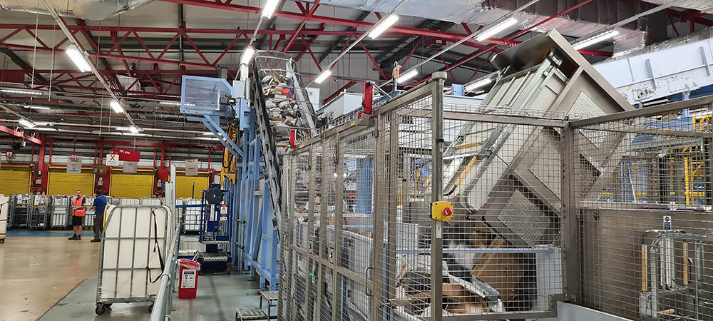Mail and parcels moving through a large machine in the mail centre.