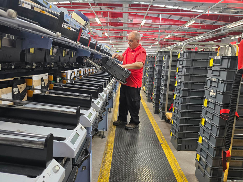 A uniformed postal worker with machinery.